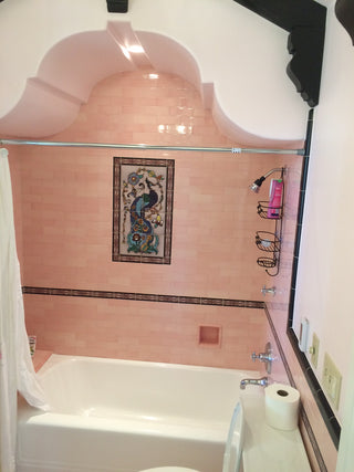 Pink subway field tiles with deco inserts, and peacock mural backsplash