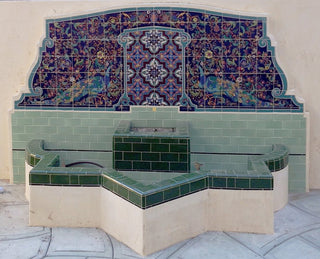 Large Spanish-style tile backsplash with historical peacock pattern